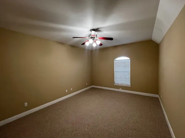 a view of an empty room with a chandelier fan