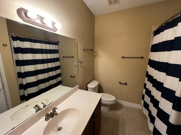 a bathroom with a sink a toilet a shower and a mirror