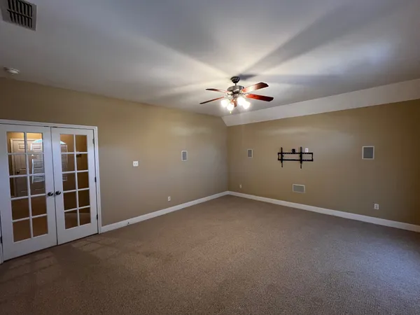 an empty room with windows and fan