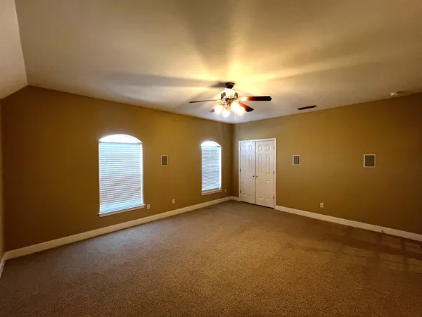 a view of an empty room with a chandelier fan