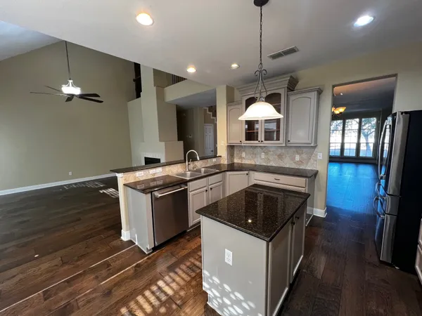 a kitchen that has a sink a stove and a wooden floor