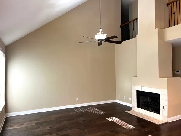 an empty room with wooden floor a fireplace