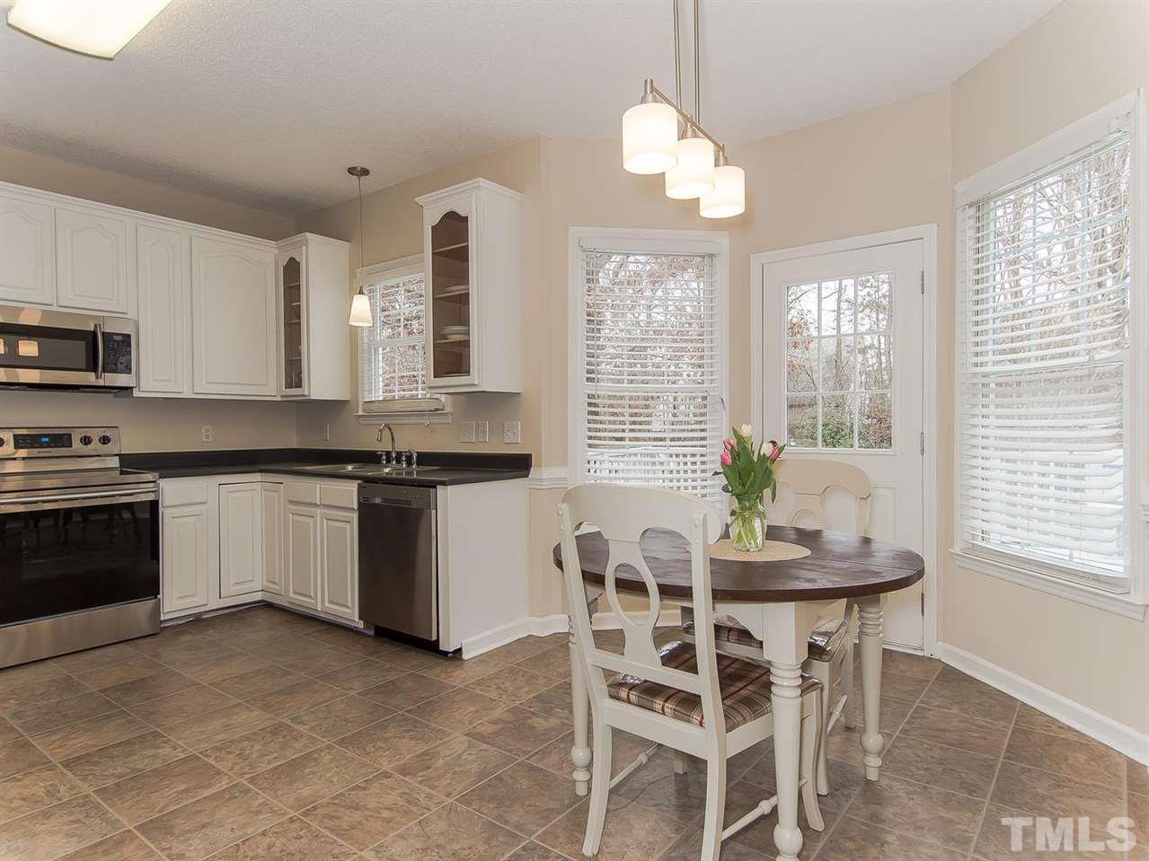 5424 Stewartby Drive Raleigh, NC 27613 - Photo 11 of 25 a kitchen with granite countertop stainless steel appliances a stove a sink and a dining table