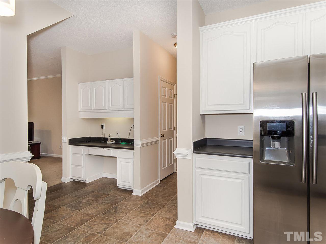 5424 Stewartby Drive Raleigh, NC 27613 - Photo 12 of 25 a kitchen with white cabinets and stainless steel appliances