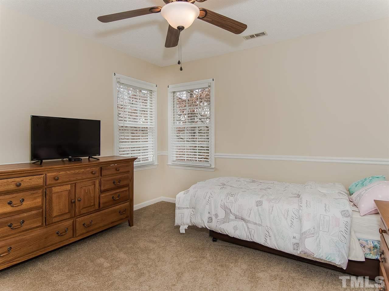 5424 Stewartby Drive Raleigh, NC 27613 - Photo 18 of 25 a bedroom with a bed and flat screen tv