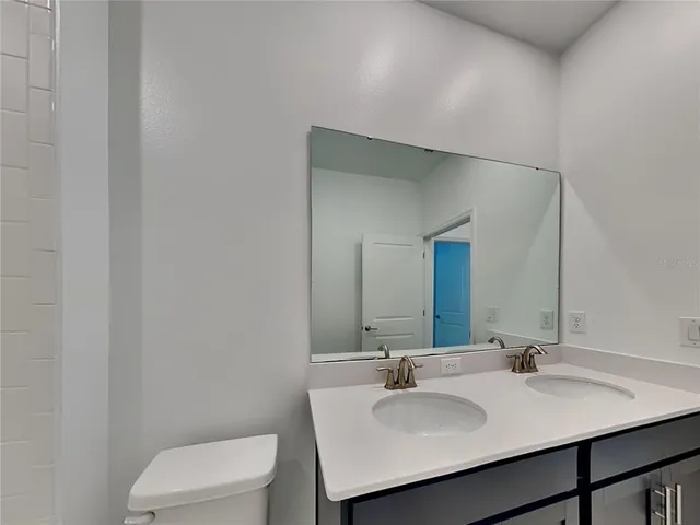 a bathroom with a toilet sink and mirror
