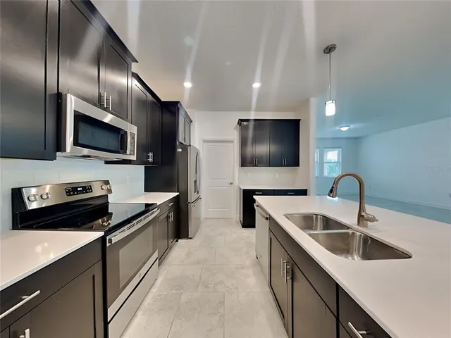 a kitchen with a sink stainless steel appliances and a counter top space