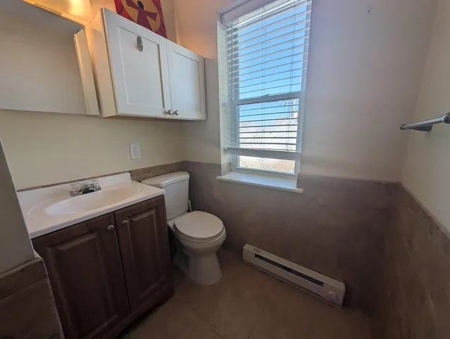 a bathroom with a sink toilet and window