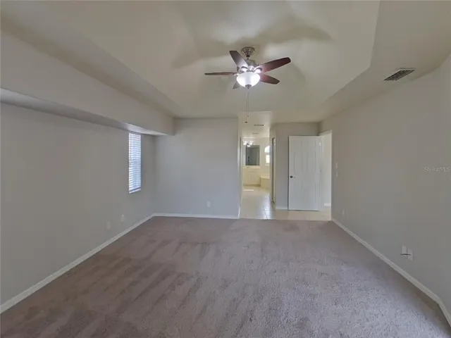 a view of an empty room with a chandelier fan