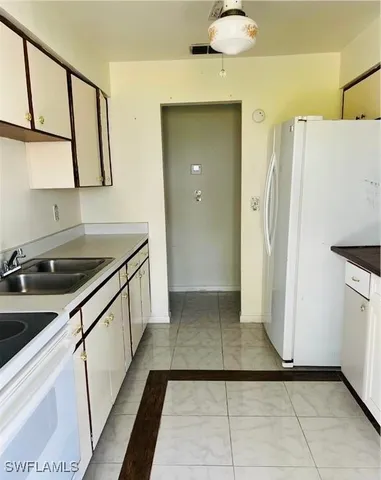a kitchen with a sink and a refrigerator