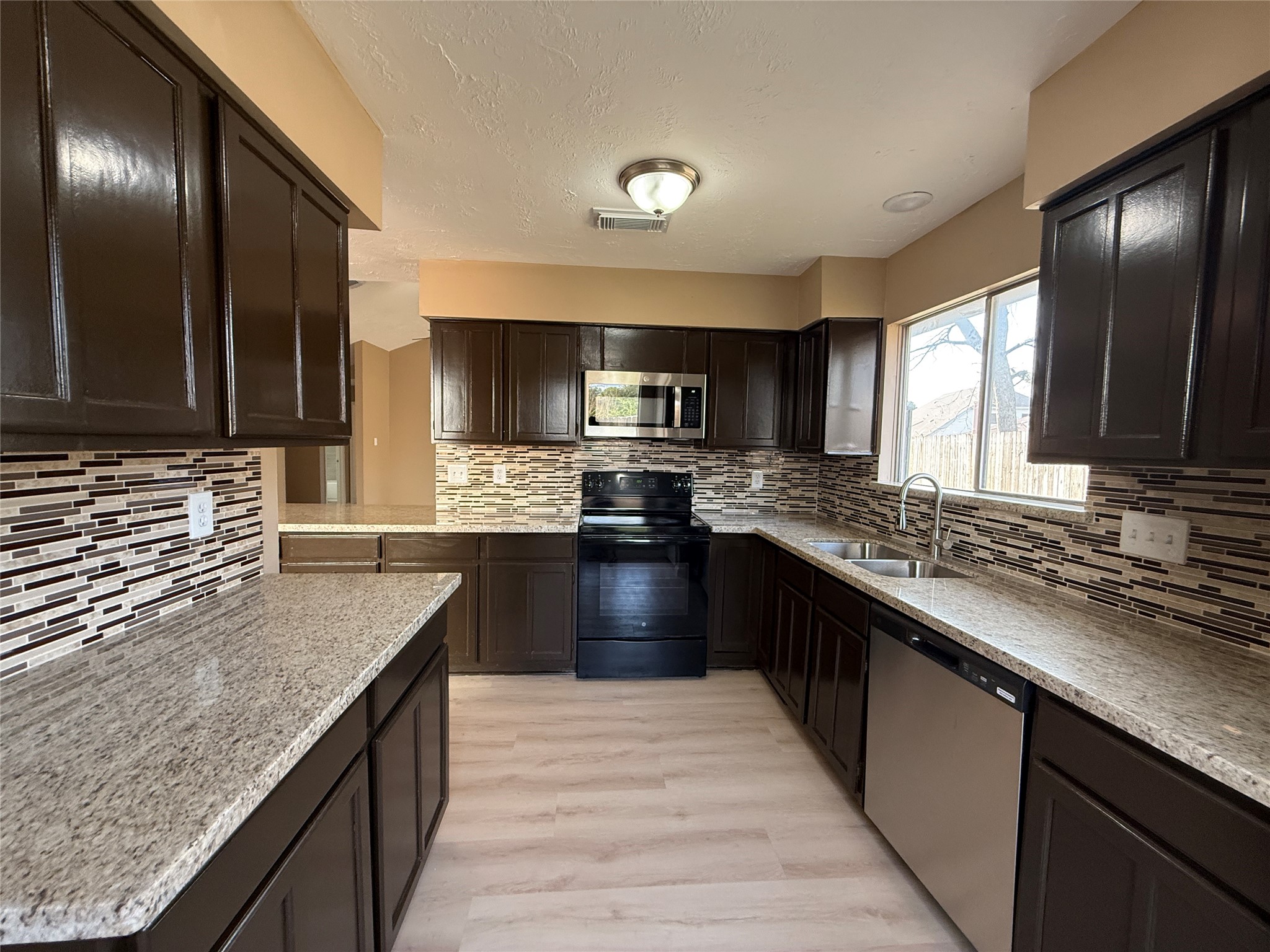 4738 Fleming Downe Lane Spring, TX 77388 - Photo 5 of 14 a large kitchen with granite countertop stainless steel appliances and wooden cabinets