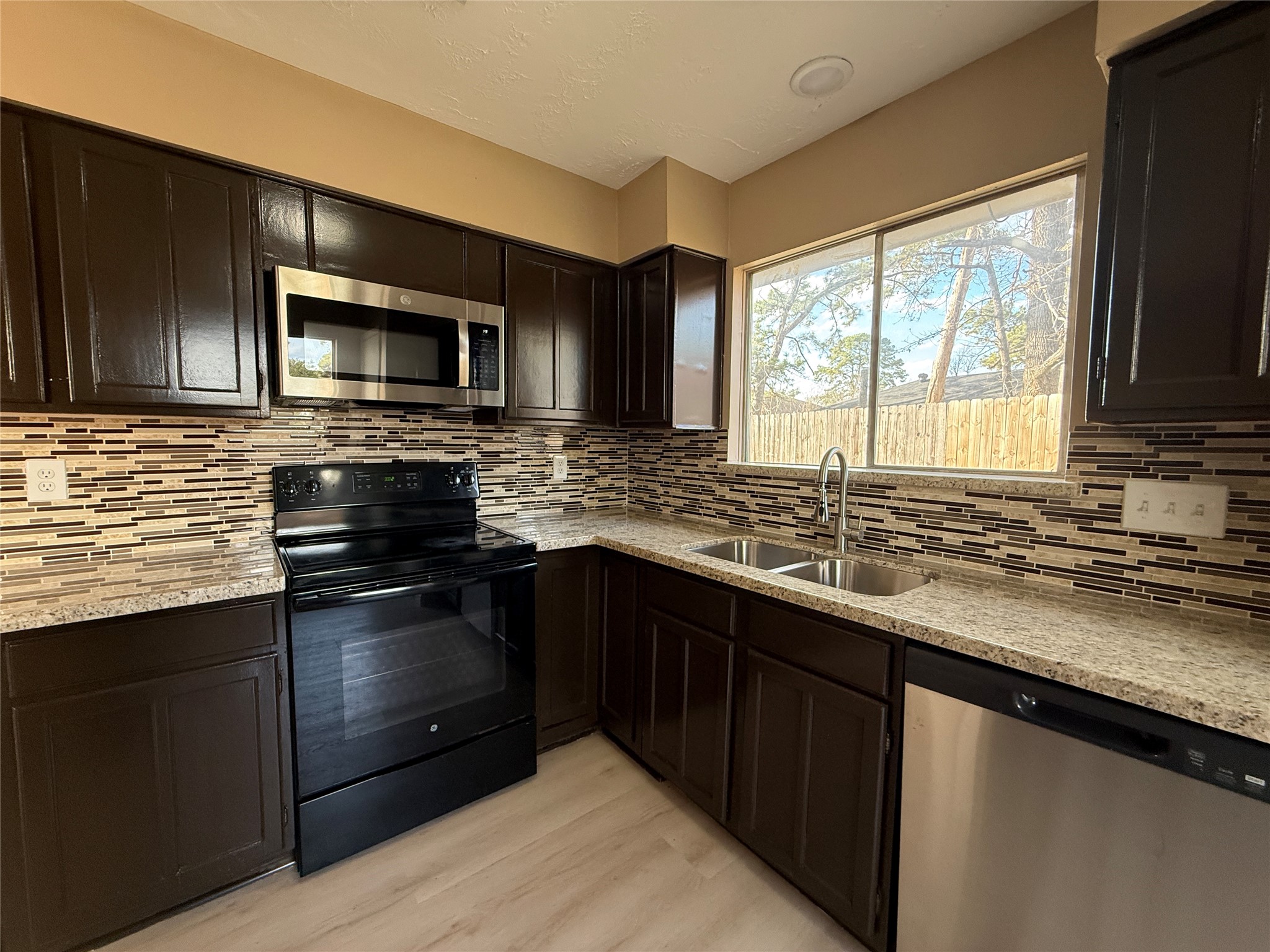 4738 Fleming Downe Lane Spring, TX 77388 - Photo 6 of 14 a kitchen with stainless steel appliances granite countertop a sink stove and microwave