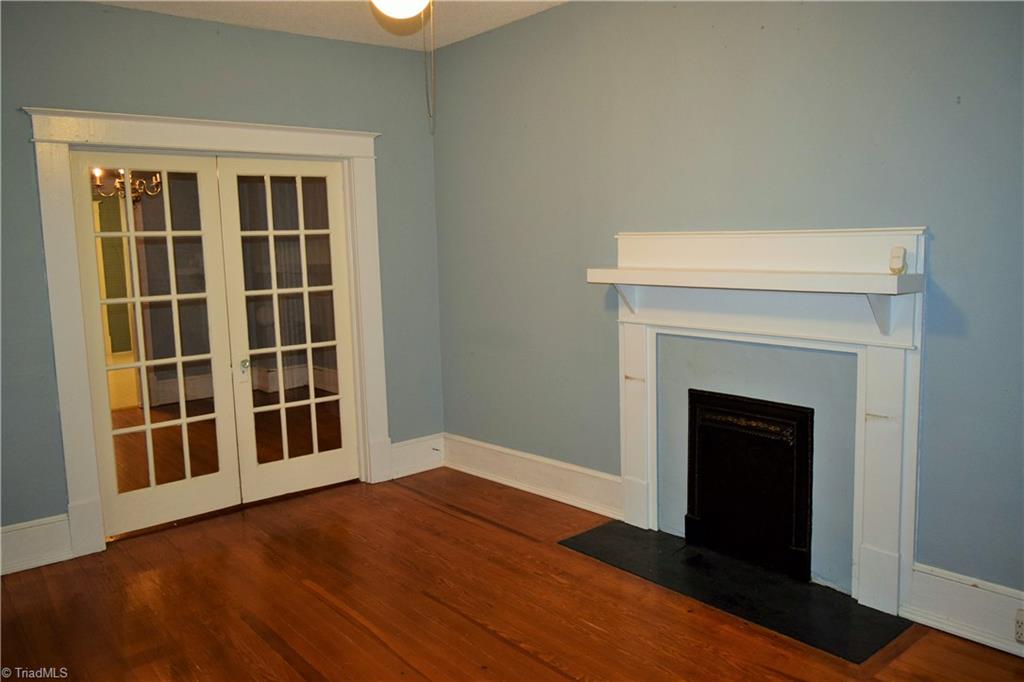 209 East Decatur Street Madison, NC 27025 - Photo 5 of 17 Livingroom has 2 glass doors leading to the dining room. Beautiful original decorative only coal burning fireplace