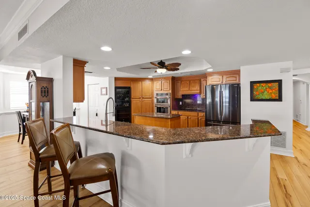 a kitchen with stainless steel appliances granite countertop a sink and a refrigerator