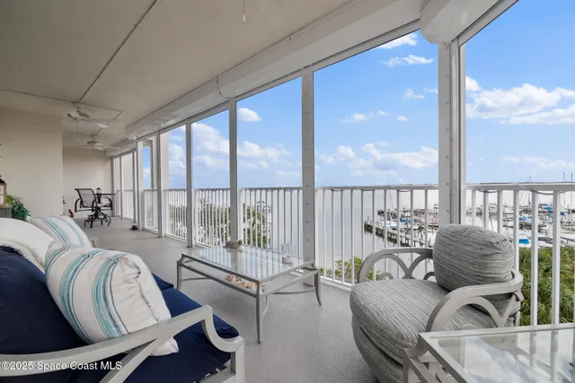 a view of a balcony with chairs and with potted plants