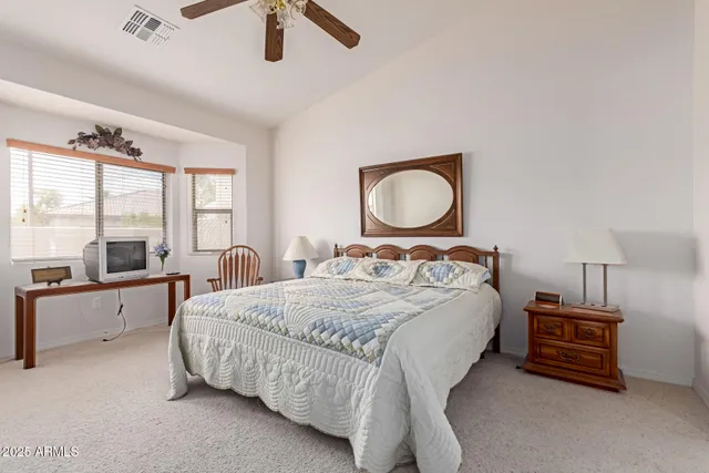 a bedroom with a bed and large windows