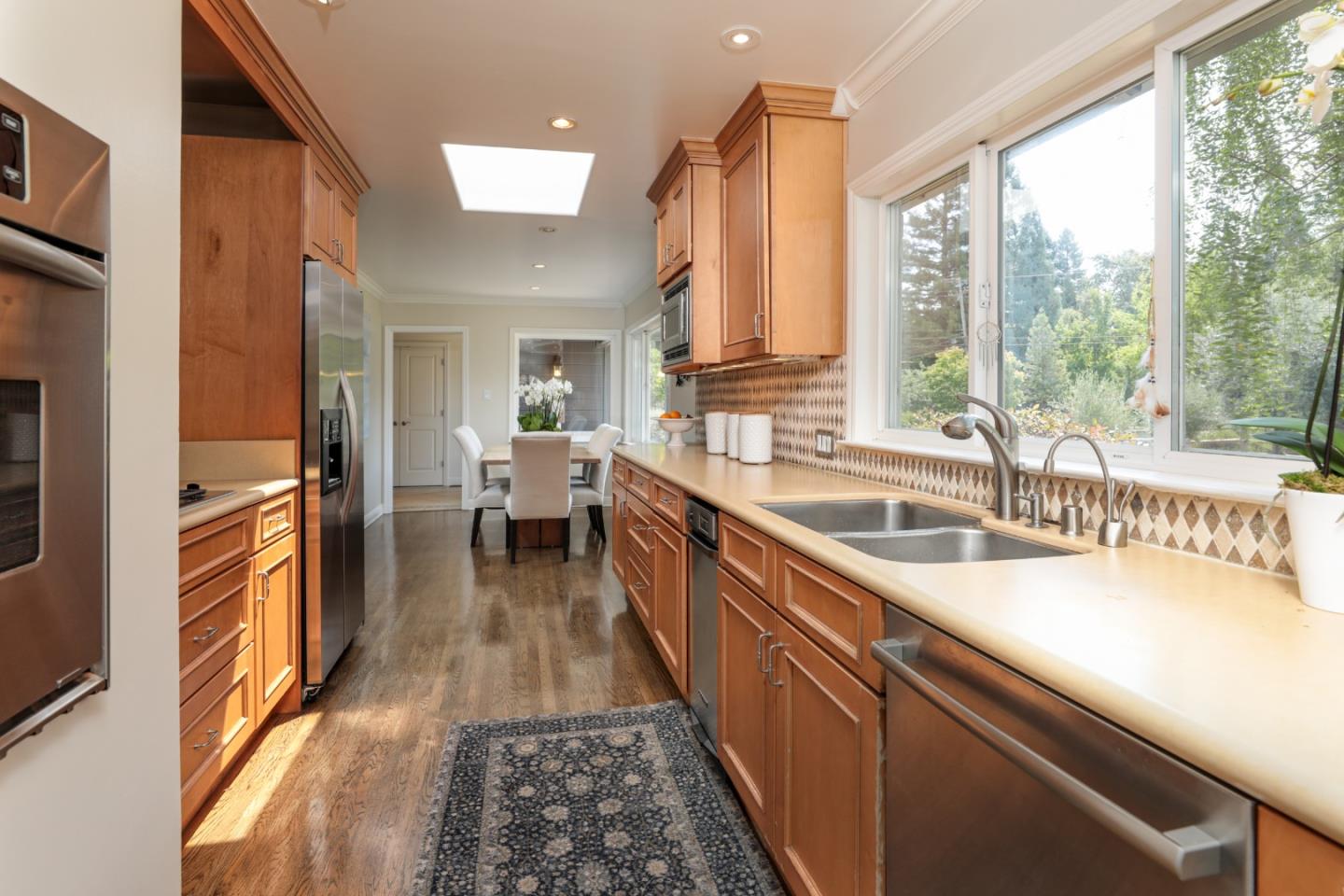 460 Cervantes Road Portola Valley, CA 94028 - Photo 11 of 45 a view of a kitchen with kitchen island a large window a sink and stainless steel appliances