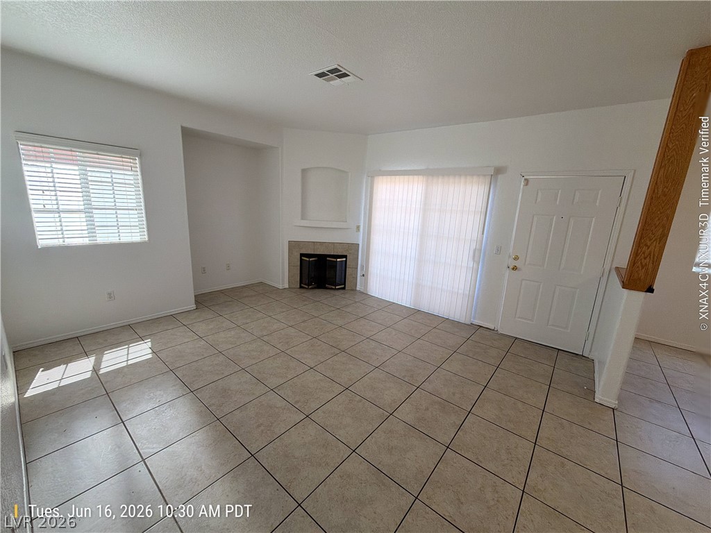 4730 East Craig Road, Unit 1124 Las Vegas, NV 89115 - Photo 4 of 22 A well-lit living area showcases tile flooring and a cozy fireplace, ready for personal touches.