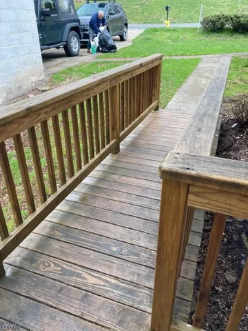a view of a porch with wooden floor and fence