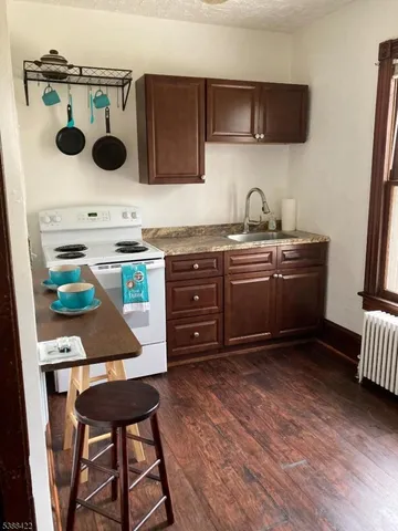 a kitchen with a sink a stove and chairs