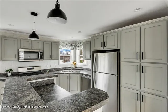 a kitchen with stainless steel appliances granite countertop a refrigerator a stove a sink and a refrigerator