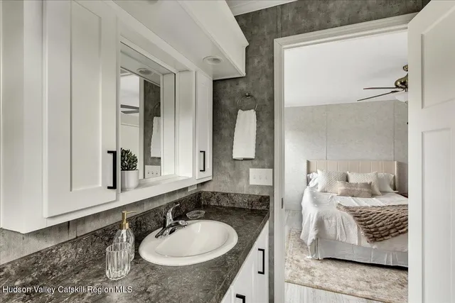 a bathroom with a granite countertop sink and a mirror