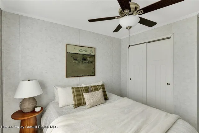 a bedroom with a bed and a lamp on the dresser