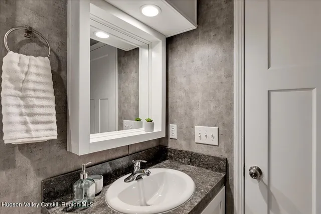 a bathroom with a granite countertop sink and a mirror