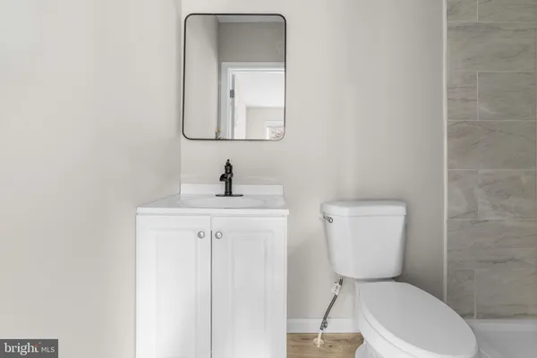 a bathroom with a toilet a sink and mirror