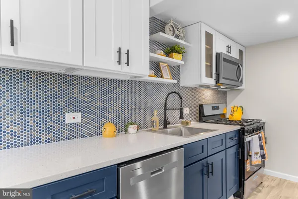 a kitchen with stainless steel appliances a sink a stove and cabinets