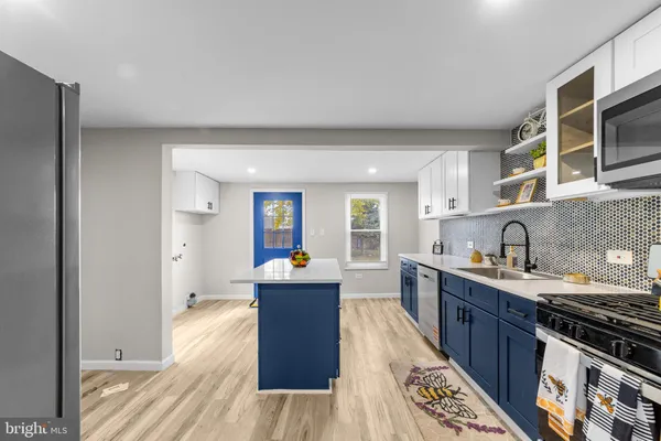 a kitchen with stainless steel appliances granite countertop a stove top oven a sink dishwasher and cabinets with wooden floor