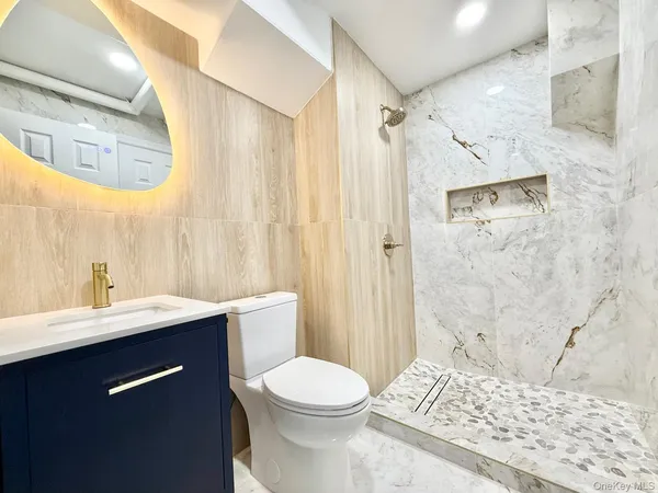 a bathroom with a sink a toilet and shower