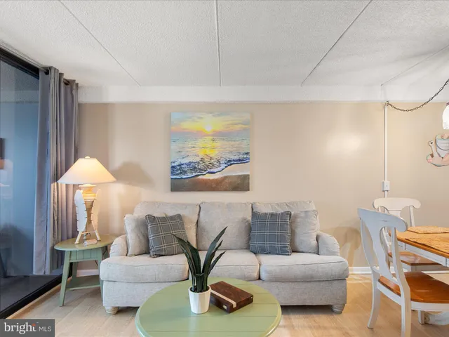 a living room with furniture a flat screen tv and kitchen view