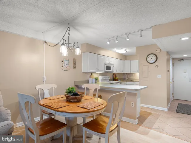a living room with furniture a chandelier and a dining table