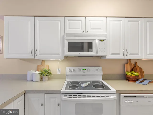 a kitchen with stainless steel appliances granite countertop a sink a refrigerator and cabinets