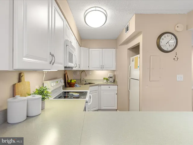 a kitchen with stainless steel appliances kitchen island granite countertop a sink dishwasher a stove and a cabinets with wooden floor