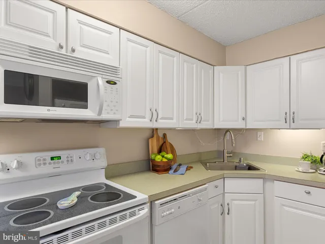 a kitchen with kitchen island a sink a stove cabinets and a counter top space