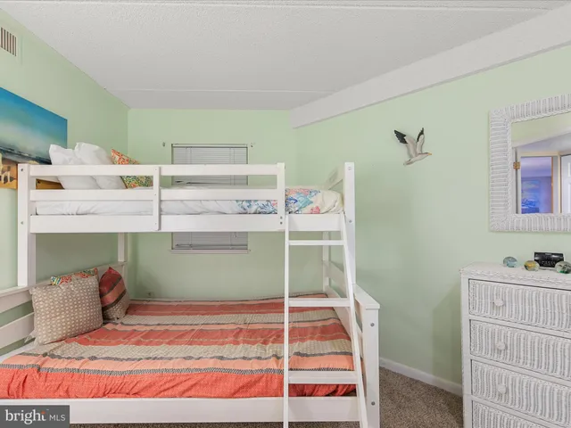 a bedroom with a large bed and a large mirror