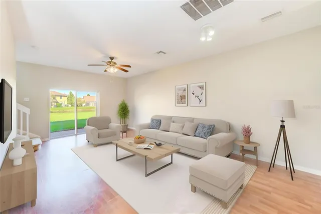 a living room with furniture wooden floor and a flat screen tv