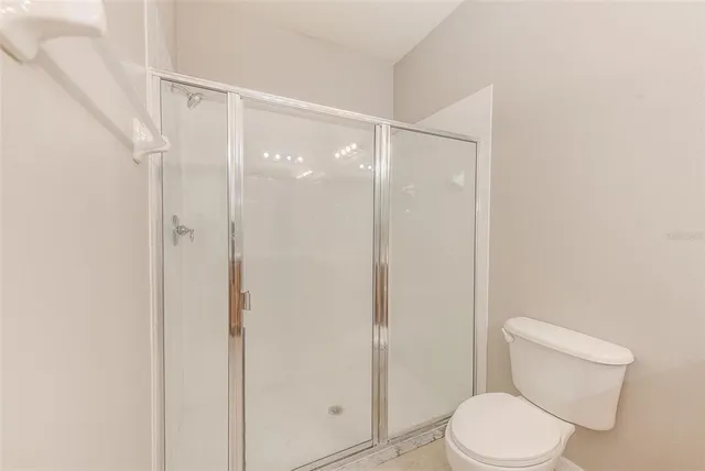 a white toilet sitting next to a shower