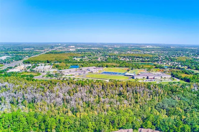 an aerial view of residential houses with outdoor space and swimming pool