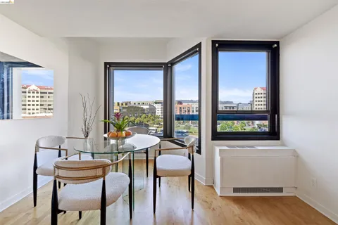 a kitchen with stainless steel appliances granite countertop a table chairs refrigerator and sink