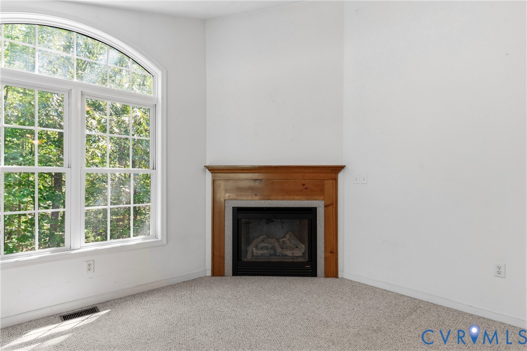 12654 Mt Olive Cohoke Road West Point, VA 23181 - Photo 9 of 31 a living room with a fireplace with windows