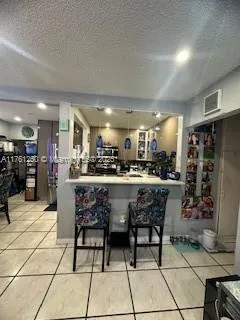 a dining hall with stainless steel appliances kitchen island granite countertop a table and chairs