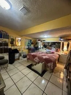 a living room with furniture a flat screen tv and kitchen view