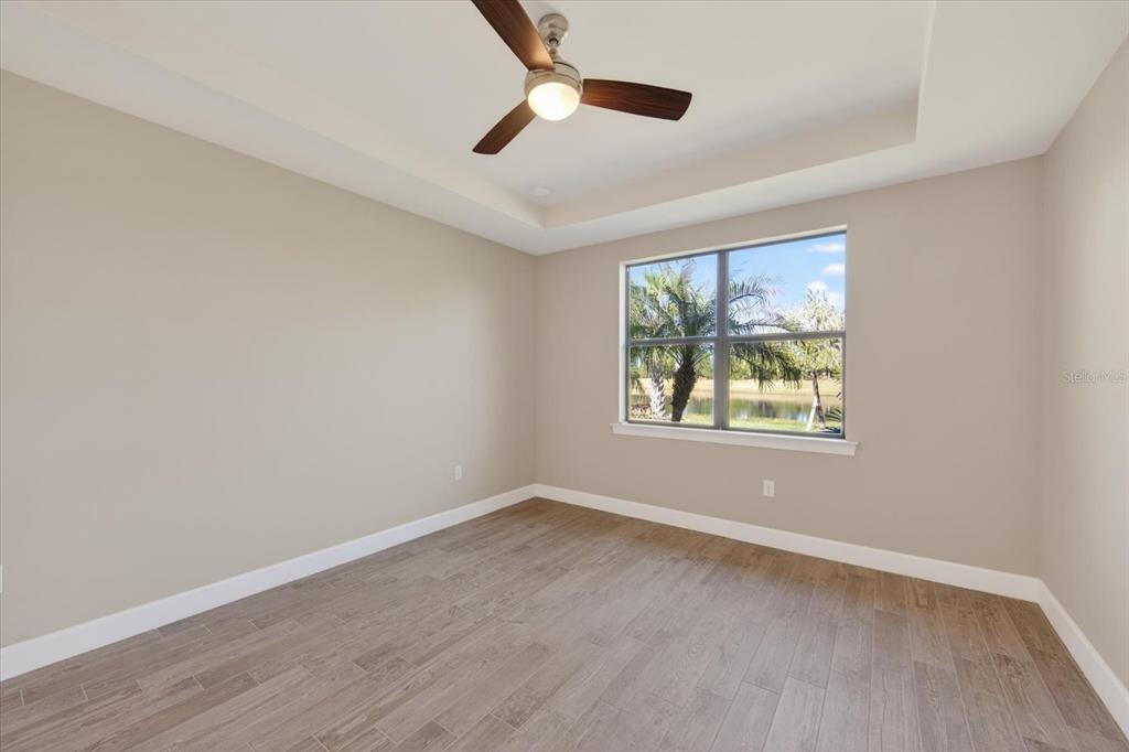 6745 Chester Trail Bradenton, FL 34202 - Photo 11 of 95 an empty room with wooden floor ceiling fan and windows