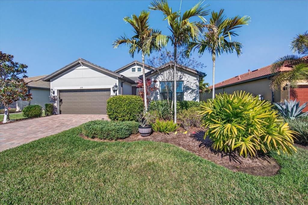 6745 Chester Trail Bradenton, FL 34202 - Photo 2 of 95 a front view of a house with a big yard and potted plants