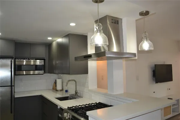 a kitchen with stainless steel appliances a stove a sink and a refrigerator