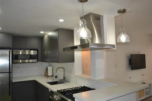 a kitchen with stainless steel appliances a stove a sink and a refrigerator