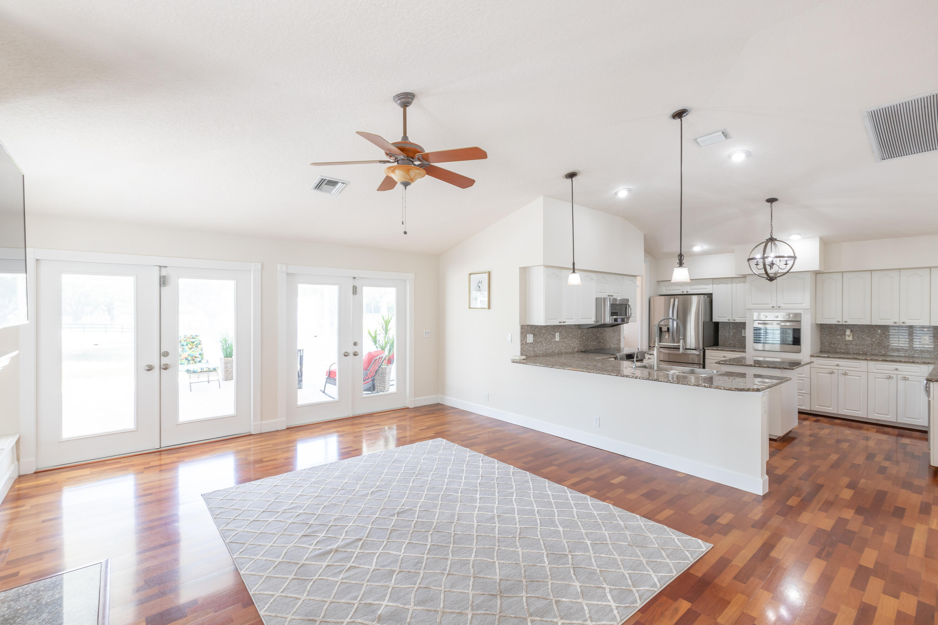 13230 Running Water Road Palm Beach Gardens, FL 33418 - Photo 8 of 32 a large kitchen with kitchen island a stove a sink a refrigerator a center island and wooden floor